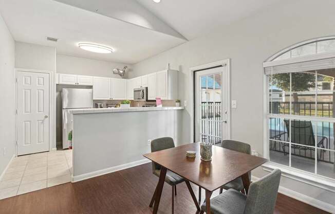 Affordable Apartments in Austin, TX for Rent- Huntington Meadows-  A clubhouse kitchen with a table and chairs in front of a window.