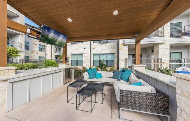 A patio with a table and chairs under a roof.
