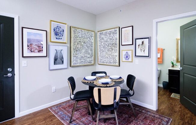 a dining room with a table and chairs and pictures on the wall