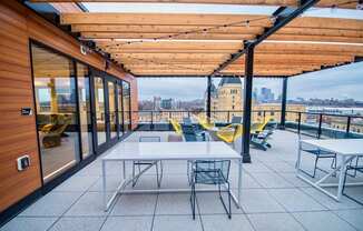 A patio with a table and chairs overlooking a cityscape.