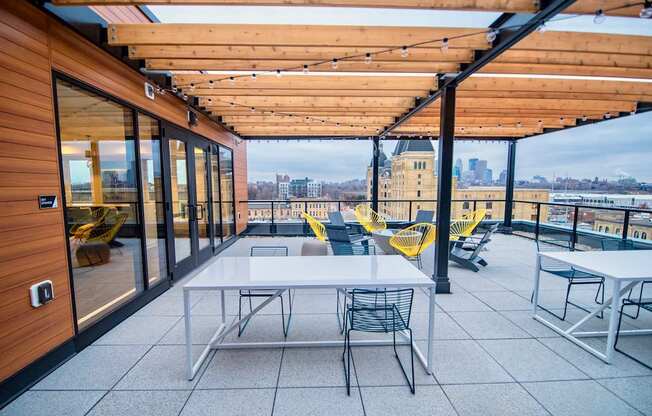 A patio with a table and chairs overlooking a cityscape.