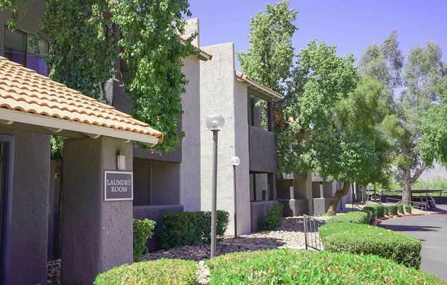 A laundry room sign is on a building in a quiet area.