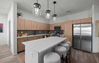 a kitchen with a large island and a stainless steel refrigerator
