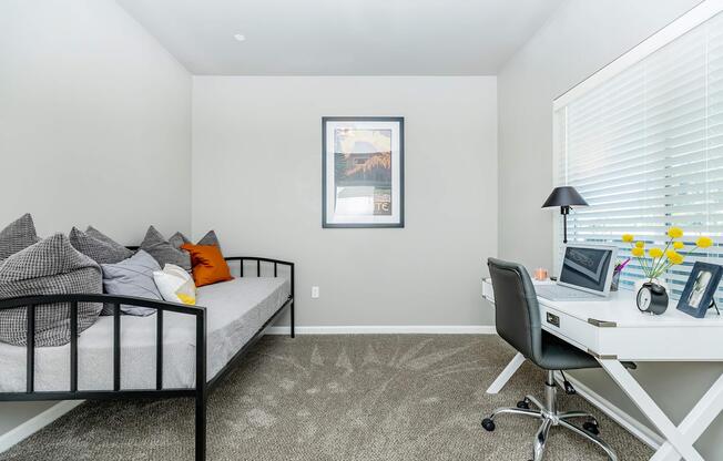 a living area with a desk and chair in a room