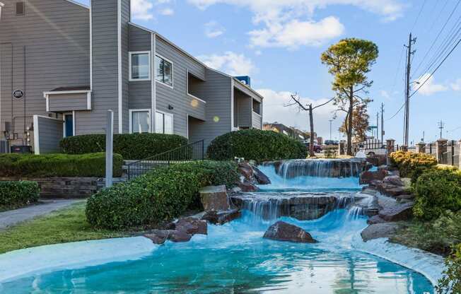 a man made waterfall in front of a house