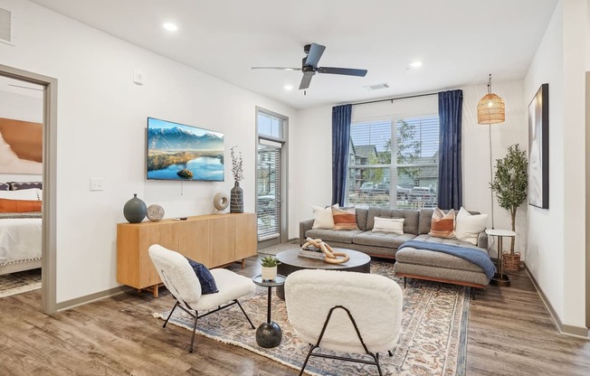 a living room with a couch and a chair and a ceiling fan