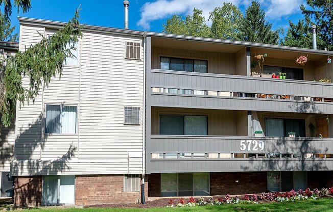 a white apartment building with a yard and grass