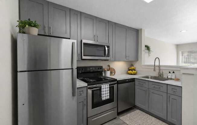 A modern kitchen with a stainless steel refrigerator and oven.
