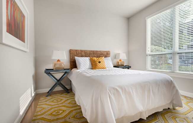 a bedroom with white walls and a yellow and white rug