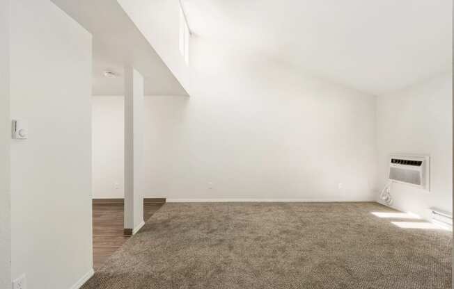 an empty living room with white walls and a carpet at Park View Apartments, Wenatchee, 98801