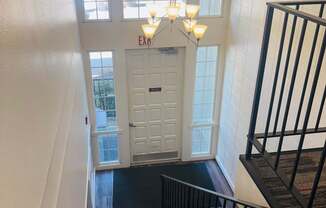 A staircase with a black railing and a white door at the top.