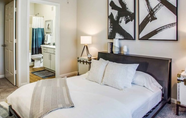 a bedroom with a large bed and a bathroom at Carrington at Barker Cypress, Texas