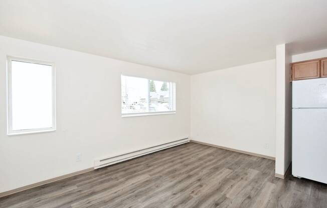 an empty room with a refrigerator and a window