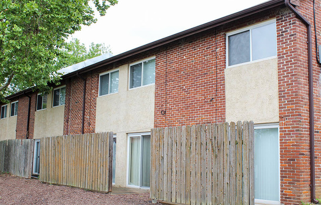 a brick building with a wooden fence in front of it