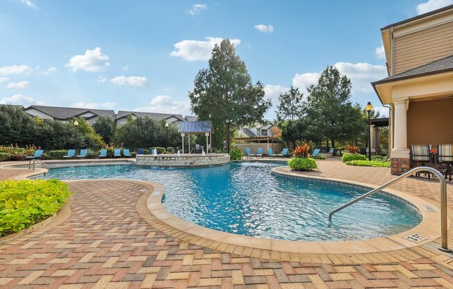 A swimming pool surrounded by a brick patio.