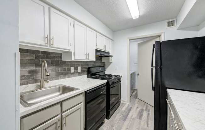 A kitchen with black appliances and white cabinets in Raleigh, NC