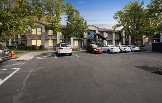 a parking lot with cars in front of an apartment building