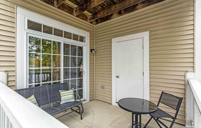 a small porch with a table and chairs and a door