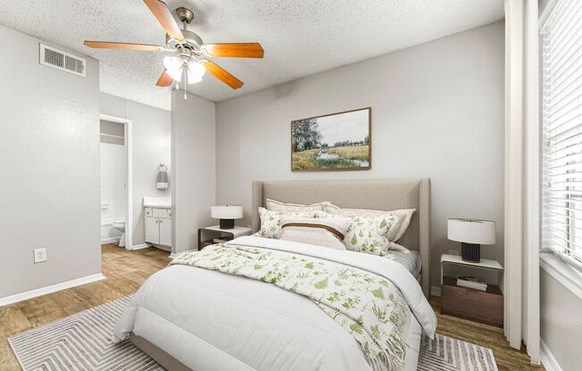 a bedroom with a large bed and a ceiling fan