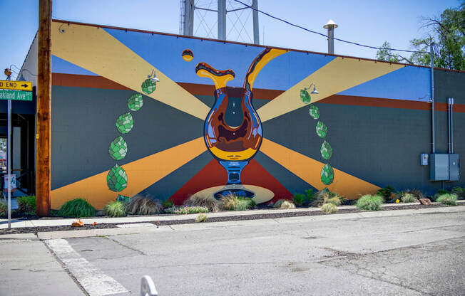 A mural of a bird with green leaves around its neck is painted on a wall.