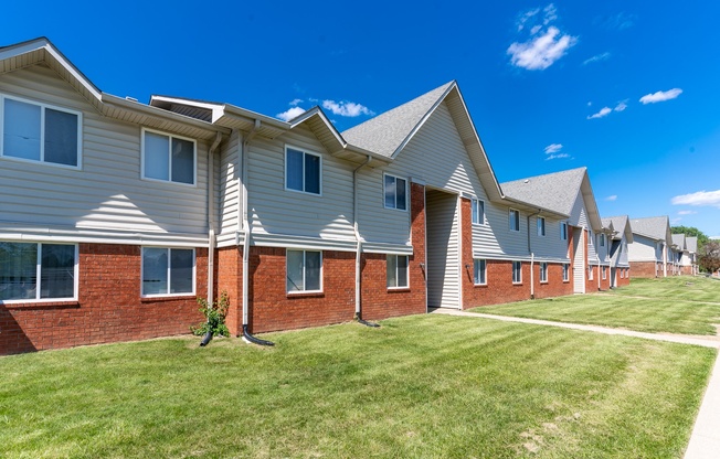 a row of houses on a green lawn