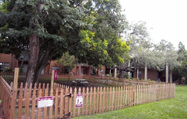 a wooden fence in front of a house with a tree