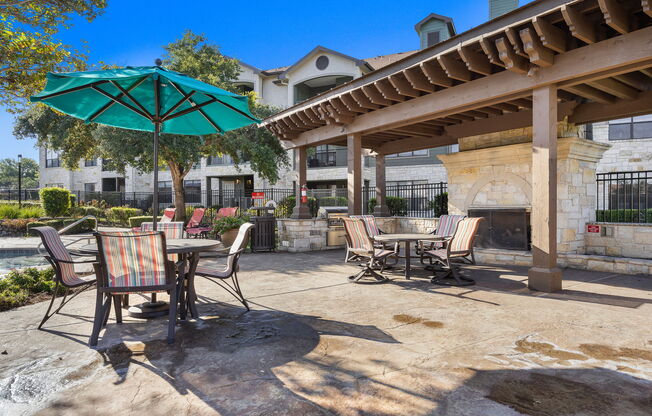 a patio with tables and chairs and umbrellas at The Fairways at Star Ranch, Hutto, Texas