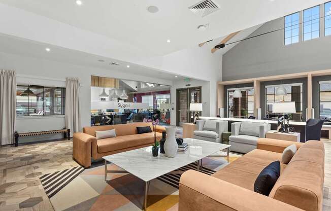 A modern living room with a variety of seating options and a large window.