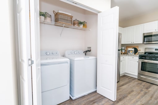 a washer and dryer in a kitchen with white cabinets