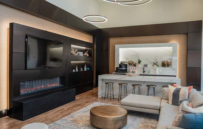 a living room with a fireplace and a bar with stools