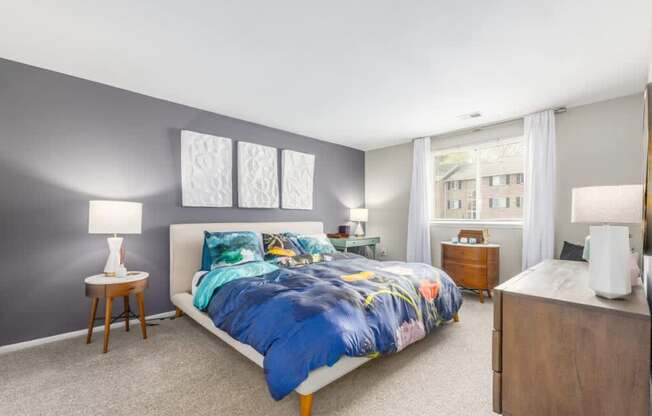 A bedroom with a large bed and a nightstand.