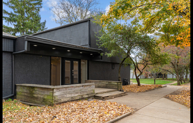 A black building with a brown door and windows.