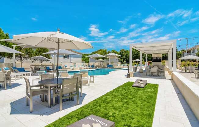 a swimming pool with tables and umbrellas at a resort