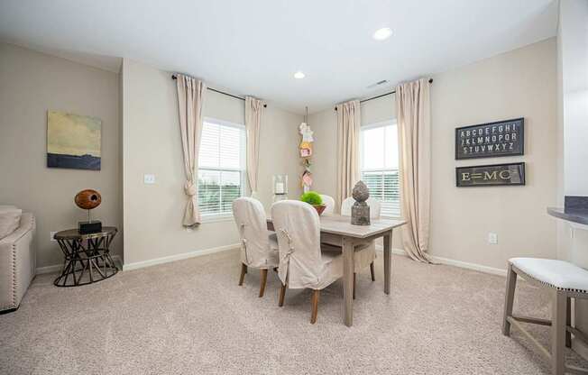 A dining room with a table and chairs.