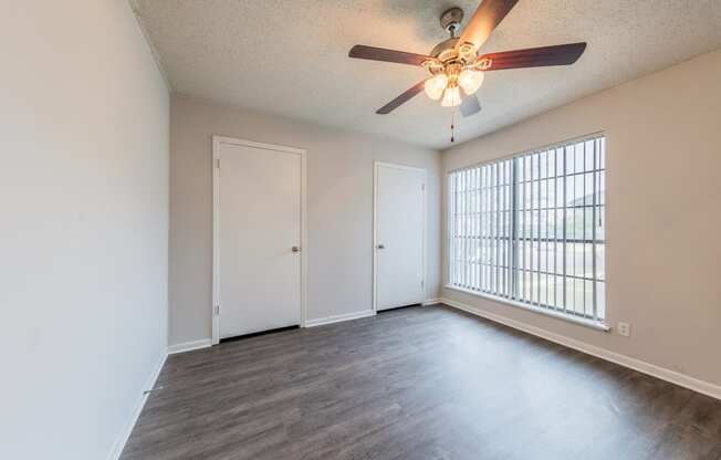 an empty living room with a ceiling fan