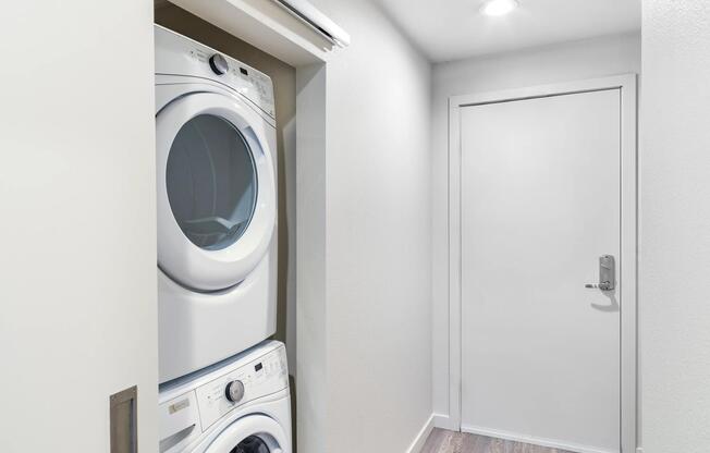 A neatly tucked in-home laundry area with a stacked washer and dryer, offering a streamlined setup that keeps daily tasks simple and out of the way.