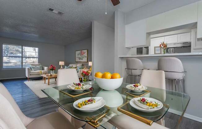 A dining room with a glass table and chairs.