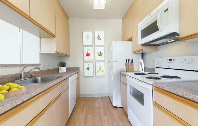 A kitchen with white appliances and wooden cabinets.