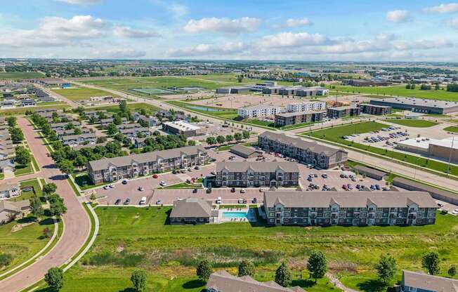 A large, modern building complex with a parking lot in front.