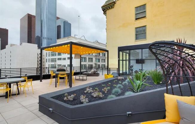 a rooftop patio with yellow chairs and a yellow umbrella