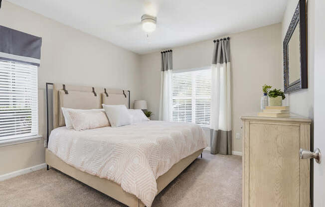 A bedroom with a large bed and a wooden cabinet.