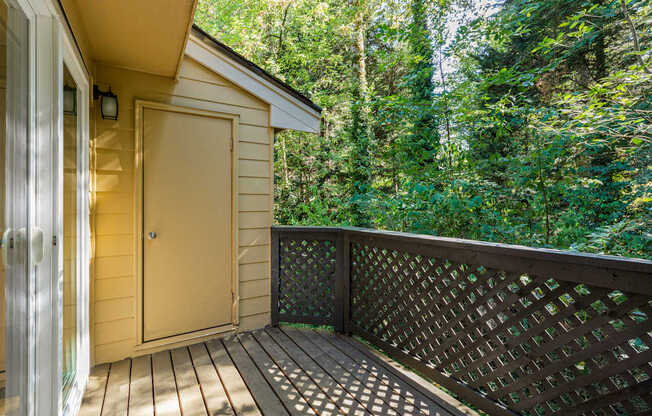 A small wooden cabin with a deck and a door.