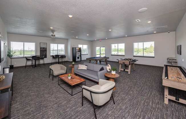 A spacious living room with grey carpeting and furniture.