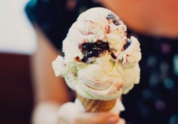 a person holding a cone with ice cream at One Ten Apartments, New Jersey
