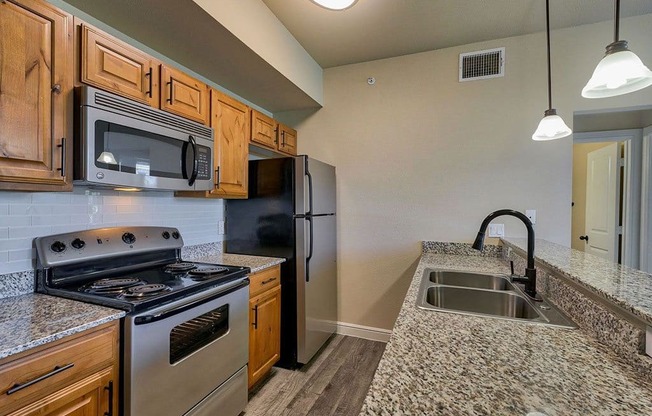 a kitchen with granite countertops and stainless steel appliances