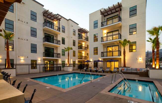A large swimming pool in front of apartment buildings.
