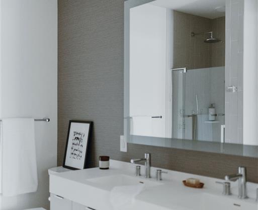 a bathroom with a white toilet and a large mirror