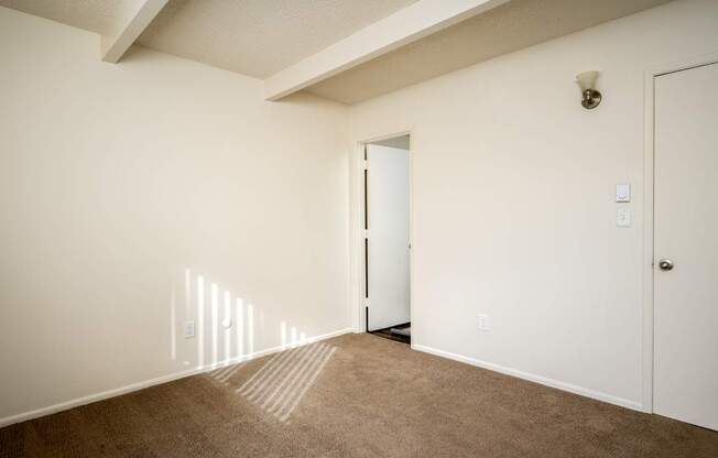 A room with a carpeted floor and a white door.
