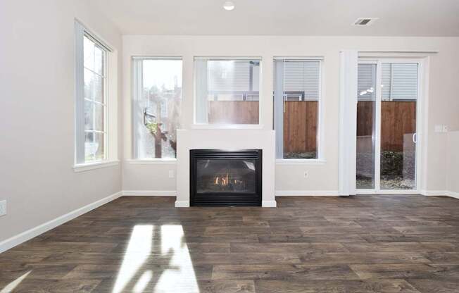 A room with a fireplace and wood flooring.