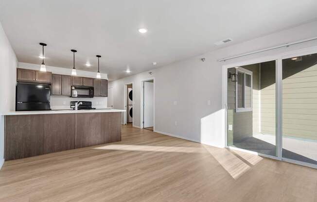 A modern kitchen with a wooden floor and white walls.